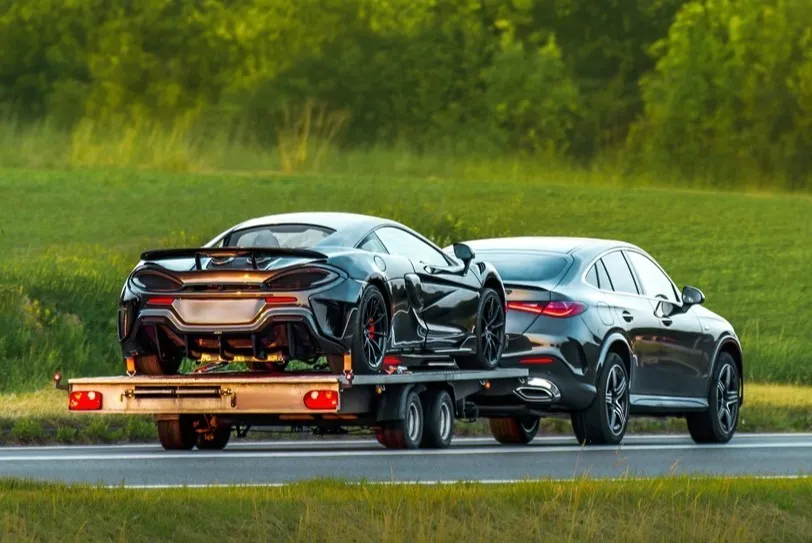 Vehicle collection and delivery: sports car being towed on a flatbed trailer